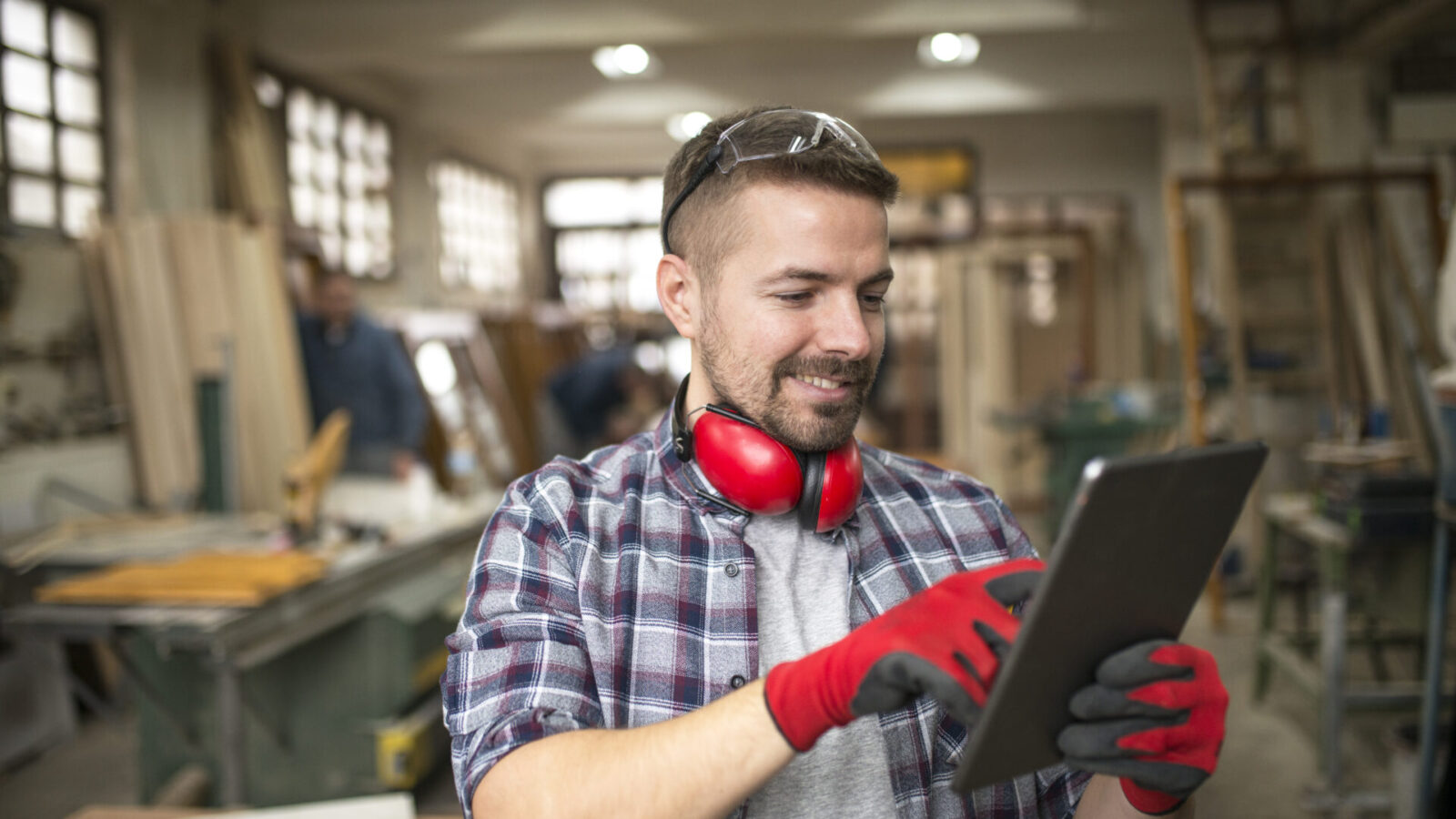 Schreiner mit Tablet in der Werkstatt: für kleine Betriebe lässt sich die KI-Sichtbarkeit mit denselben Mitteln verbessern wie das Ranking